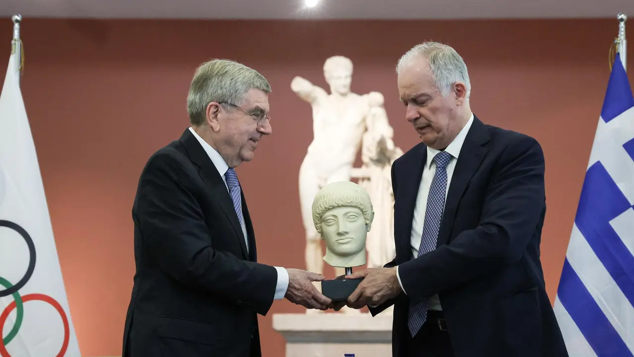 Una foto cedida por la Oficina Presidencial Griega que muestra al presidente de Grecia, Konstantinos Tasoulas (der. y al presidente del Comit&eacute; Ol&iacute;mpico Internacional (COI), Thomas Bach (izq.), intercambiando regalos. EFE/EPA/THEODOR MANOLOPOULOS / GREEK PRESIDENTIAL OFFICE